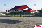 Namiot reklamowy z herbem klubu 3x6m – STADION – widok frontu Namiot ekspresowy 3x6m z pełnym nadrukiem w barwach klubowych – czerwień i granat – rozstawiony na boisku piłkarskim, widok od frontu bez ścian bocznych