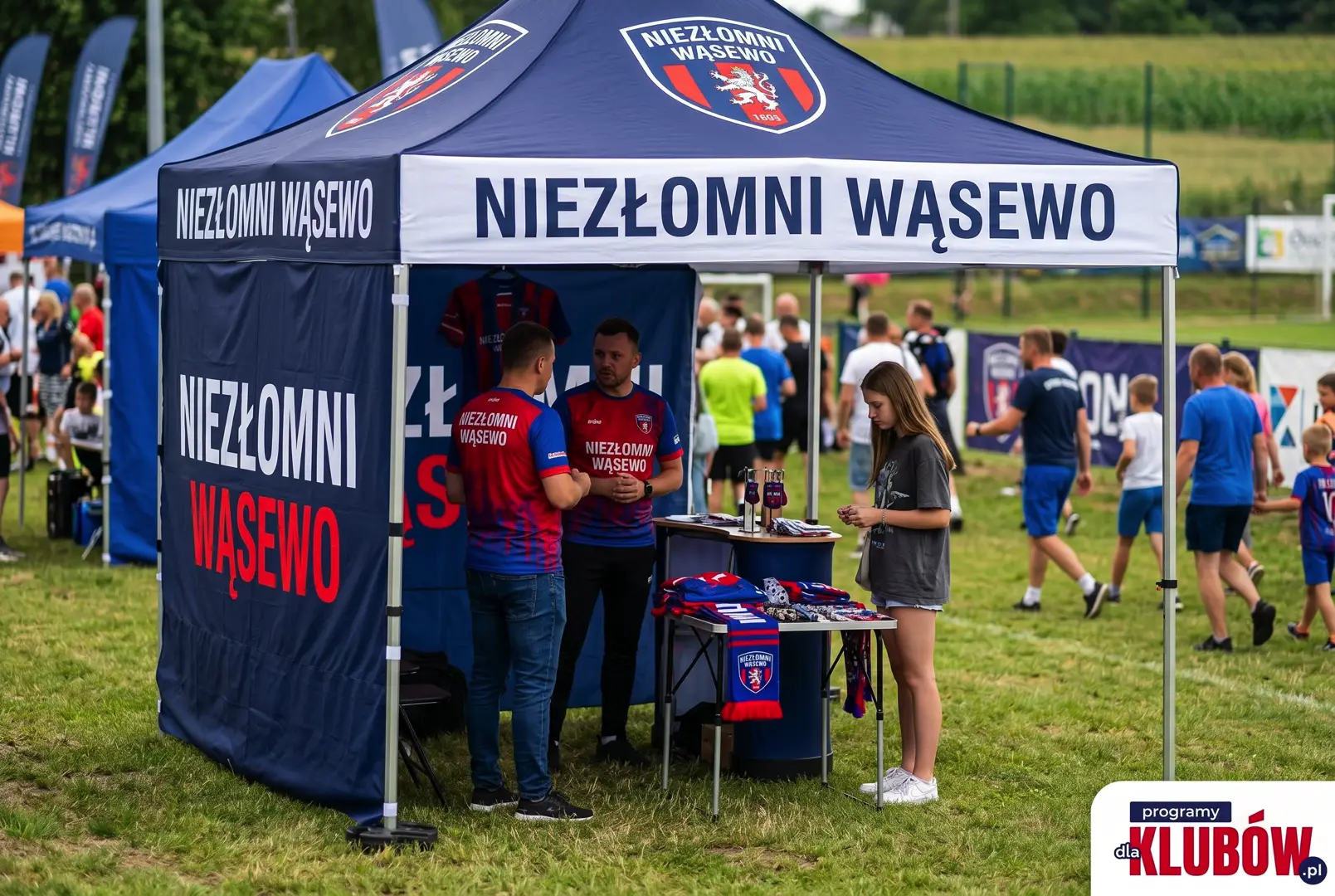 Namiot reklamowy klubu Niezlomni Wasewo ustawiony przy boisku podczas zawodów sportowych